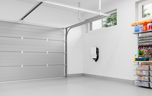 Interior of an empty modern residential garage with EV charger.