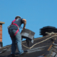 Construction Man Roofer Working On Roof Removing Shingles Repair
