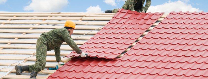 Rubber roofing - workers on roof at works with metal tile